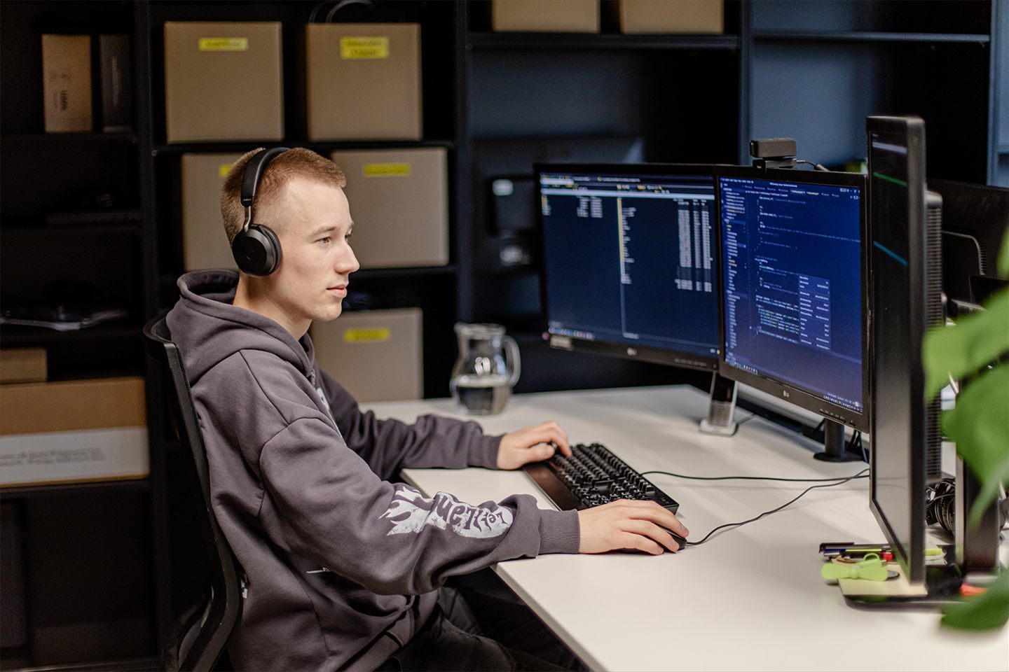 An IT employee working at multiple monitors