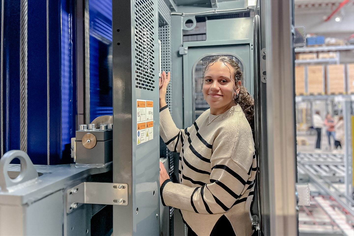 An employee at a machine in the high-bay warehouse